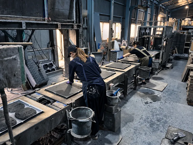 型の並ぶ製造ラインで作業するスタッフ